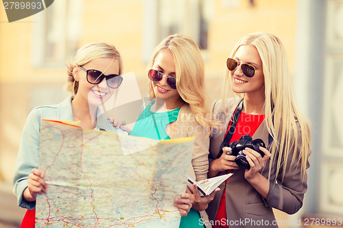 Image of beautiful women with tourist map in the city