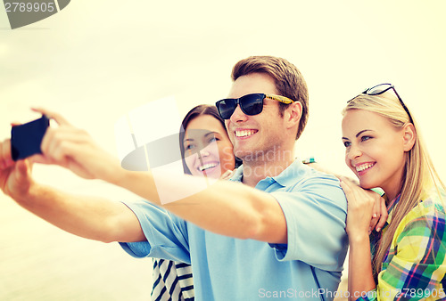 Image of group of friends taking picture with smartphone