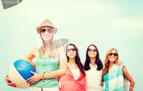 Image of girl with ball and friends on the beach