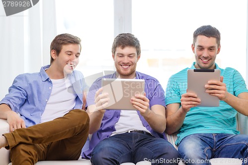 Image of smiling friends with tablet pc computers at home