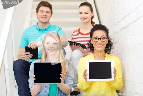 Image of smiling students showing tablet pc blank screen