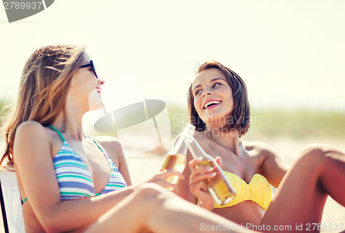 Image of girls with drinks on the beach chairs