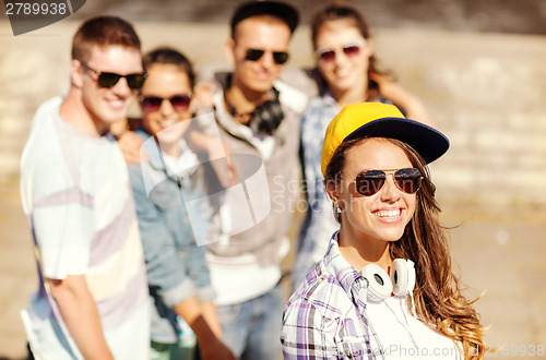 Image of teenage girl with headphones and friends outside