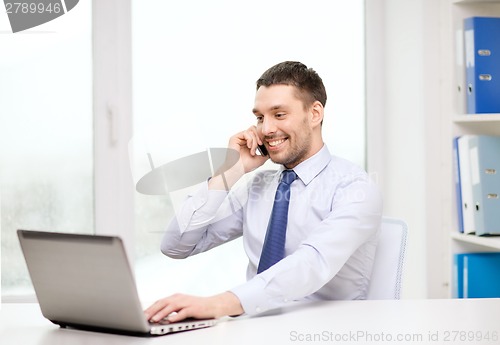 Image of businessman with laptop and smartphone at office