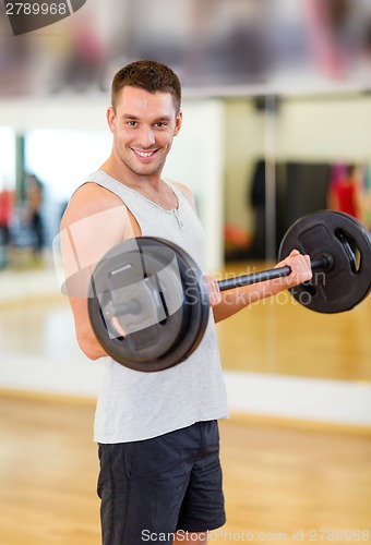 Image of smiling man with barbell in gym