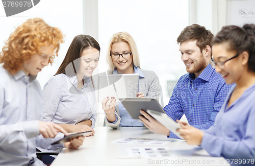 Image of smiling team with table pc and papers working