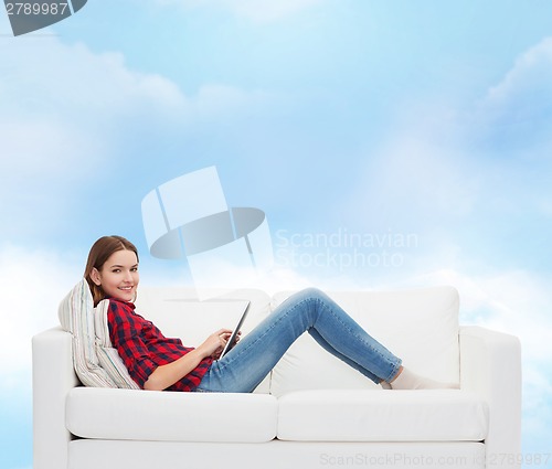 Image of teenage girl sitting on sofa with tablet pc