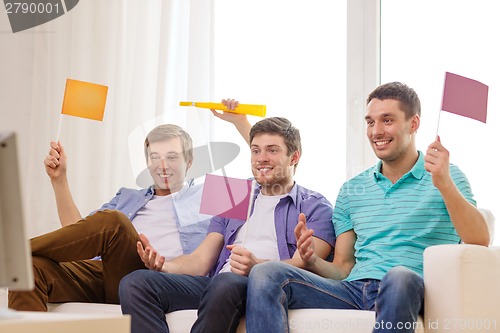 Image of happy male friends with flags and vuvuzela