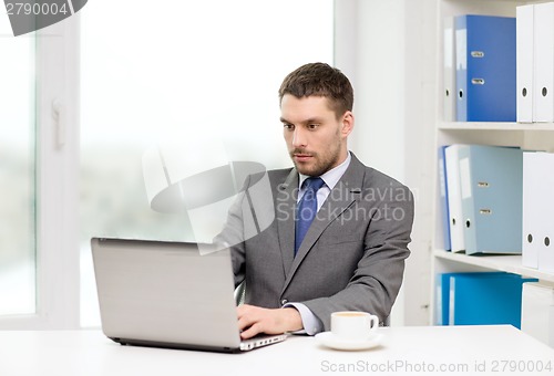 Image of busy businessman with laptop and coffee