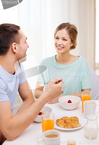 Image of smiling couple having breakfast at home