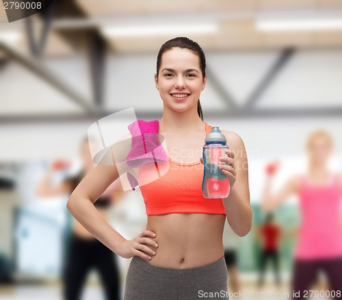 Image of sporty woman with towel and water bottle