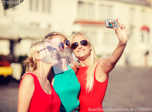 Image of three beautiful girls taking picture in the city