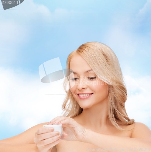 Image of beautiful woman applying cream