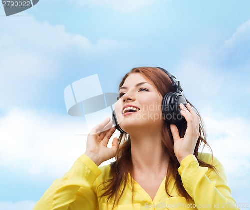 Image of smiling young girl in headphones at home