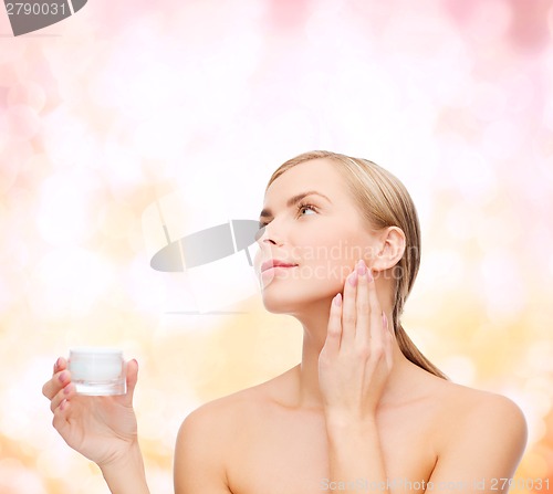 Image of woman applying cream on her skin