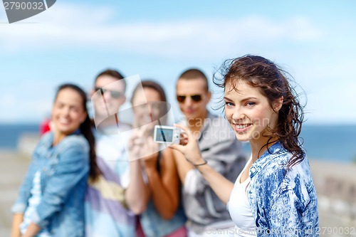 Image of happy teenagers taking photo outside