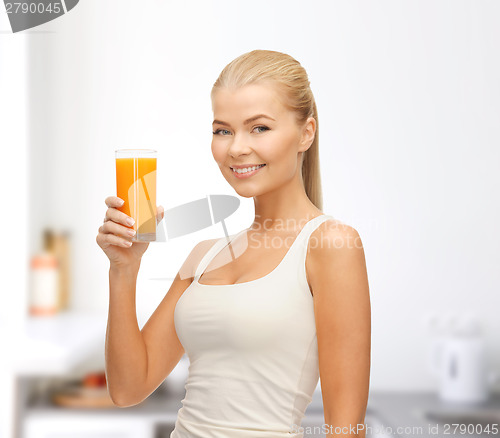 Image of smiling woman holding glass of orange juice