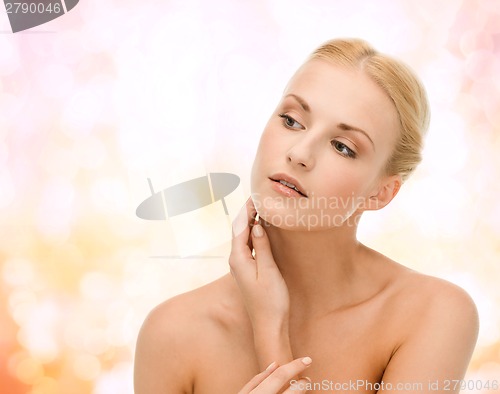 Image of beautiful woman touching her face skin