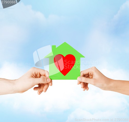 Image of couple hands holding green paper house