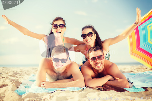 Image of group of smiling people having fun on the beach