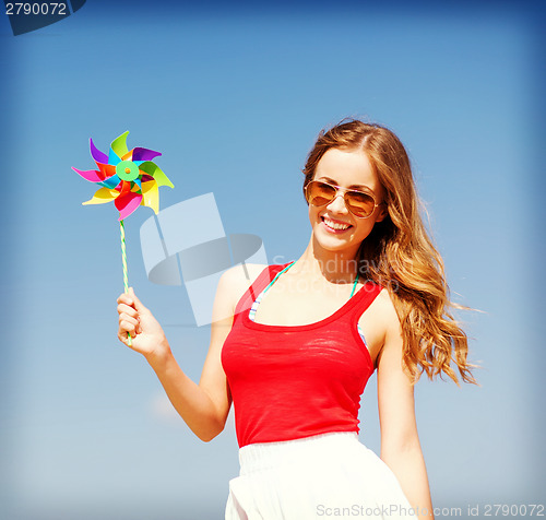 Image of girl with windmill toy on the beach