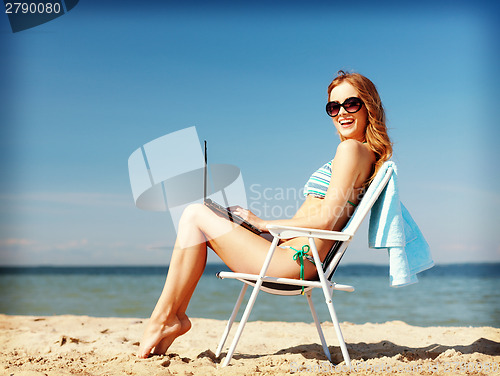 Image of girl looking at tablet pc on the beach