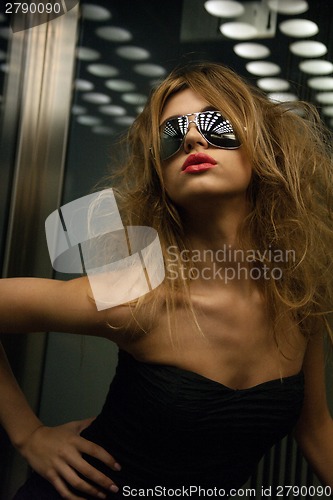 Image of beautiful woman in sunglasses in elevator