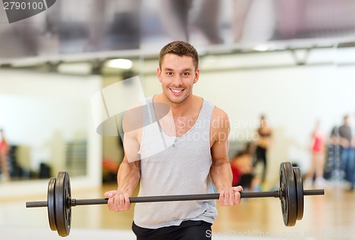 Image of smiling man with barbell in gym
