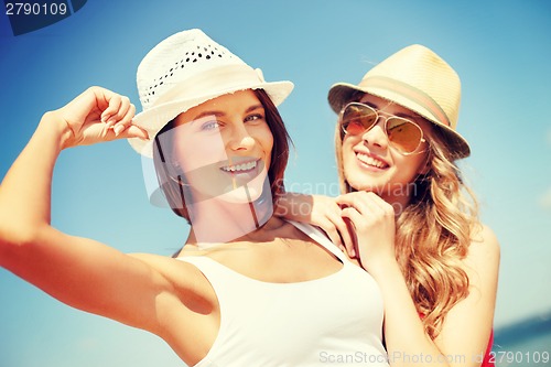 Image of girls in hats on the beach