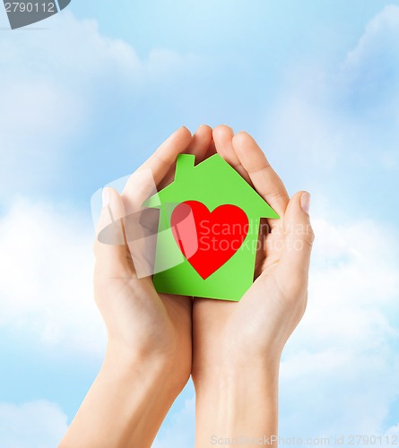 Image of hands holding green paper house