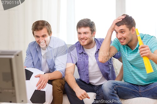 Image of happy male friends with football and vuvuzela