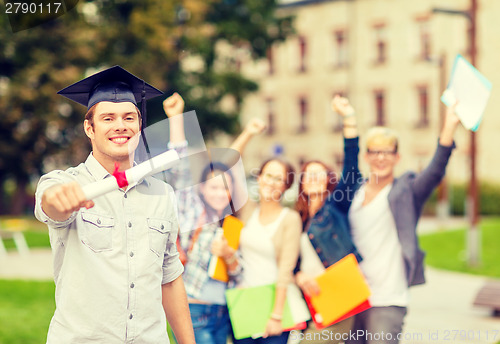 Image of smiling teenage boy in corner-cap with diploma
