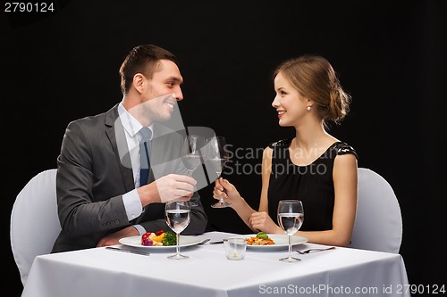 Image of smiling couple eating main course at restaurant