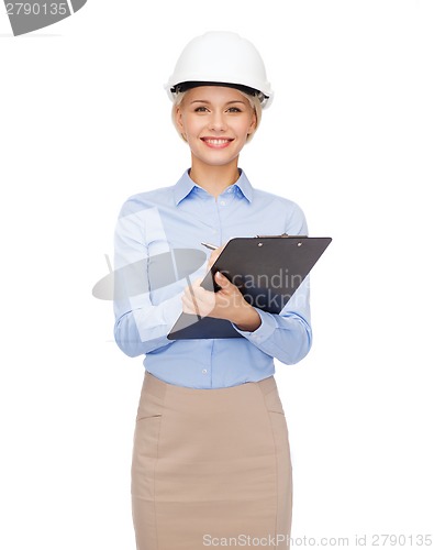 Image of smiling businesswoman in helmet with clipboard