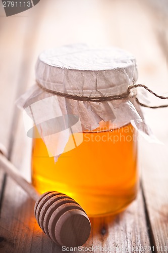 Image of full honey pot and honey stick 