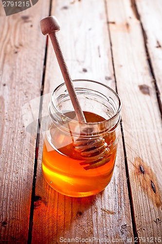 Image of full honey pot and honey stick 