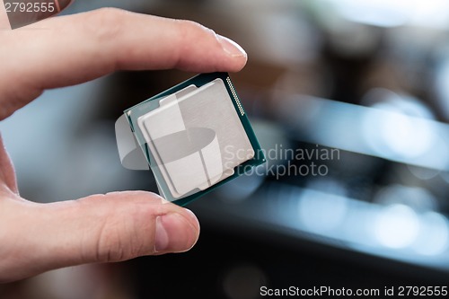 Image of Human hand holding modern processor