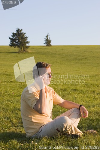 Image of Man with cell phone in a meadow