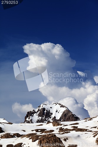 Image of Rocks in snow and blue sky with clouds