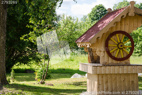 Image of wooden handmade well in summer garden 