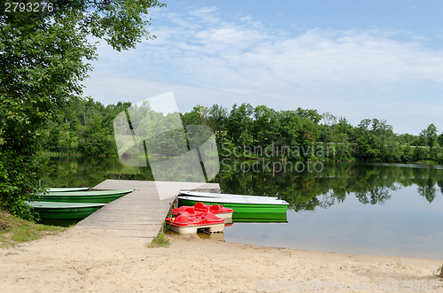 Image of wooden footbridge and anchored boats water bikes  