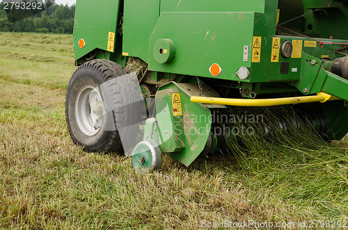 Image of press machine form round fresh hay straw bale roll 