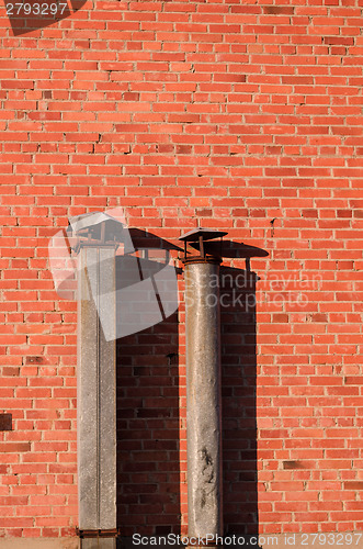 Image of metal pipes to red brick wall house 