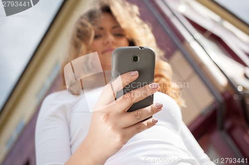 Image of Woman using cellphone on the street