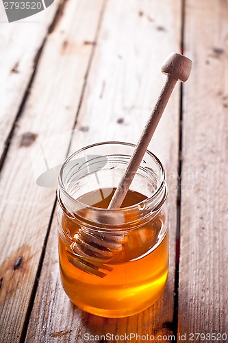 Image of full honey pot and honey stick 