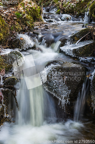 Image of Small waterfall with icicles and ice close up, spring.