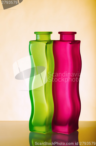 Image of Two elegant green and red vases on a yellow background, a close 
