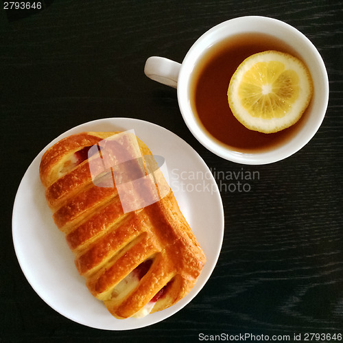 Image of Pastry and cup of tea with lemon