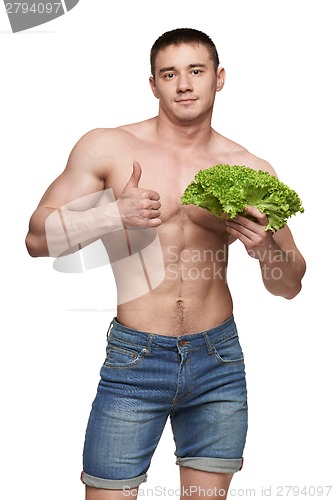 Image of Fit male holding vegetables and showing thumbs up