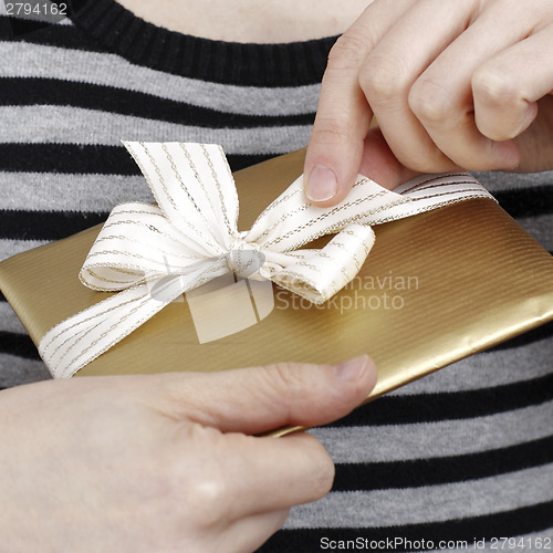 Image of Young woman holding a present